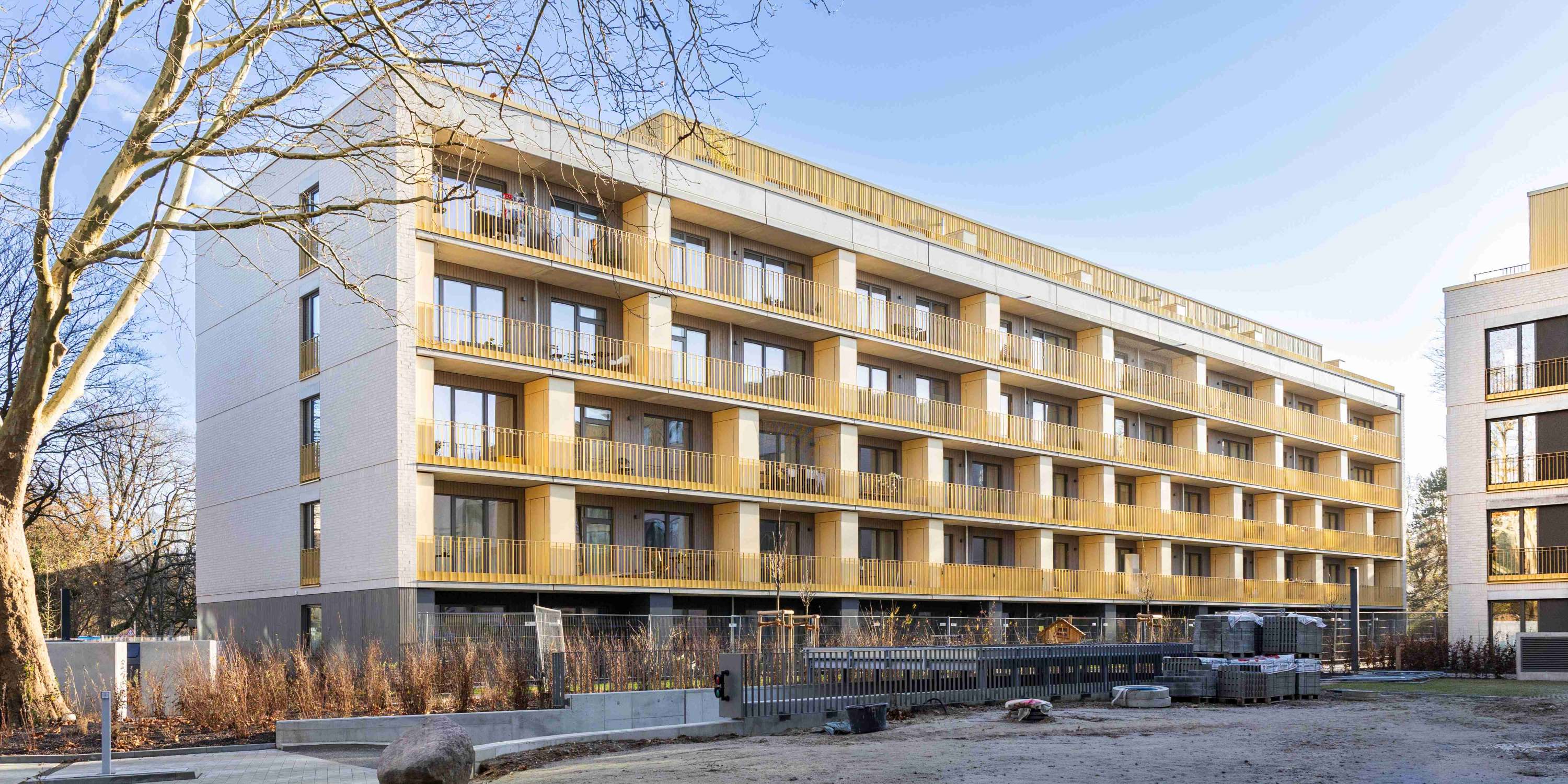 Seitenansicht des Gebäudes mit Fokus auf die glatte, weiße Fassade und die klaren Linien der Fensterfronten.