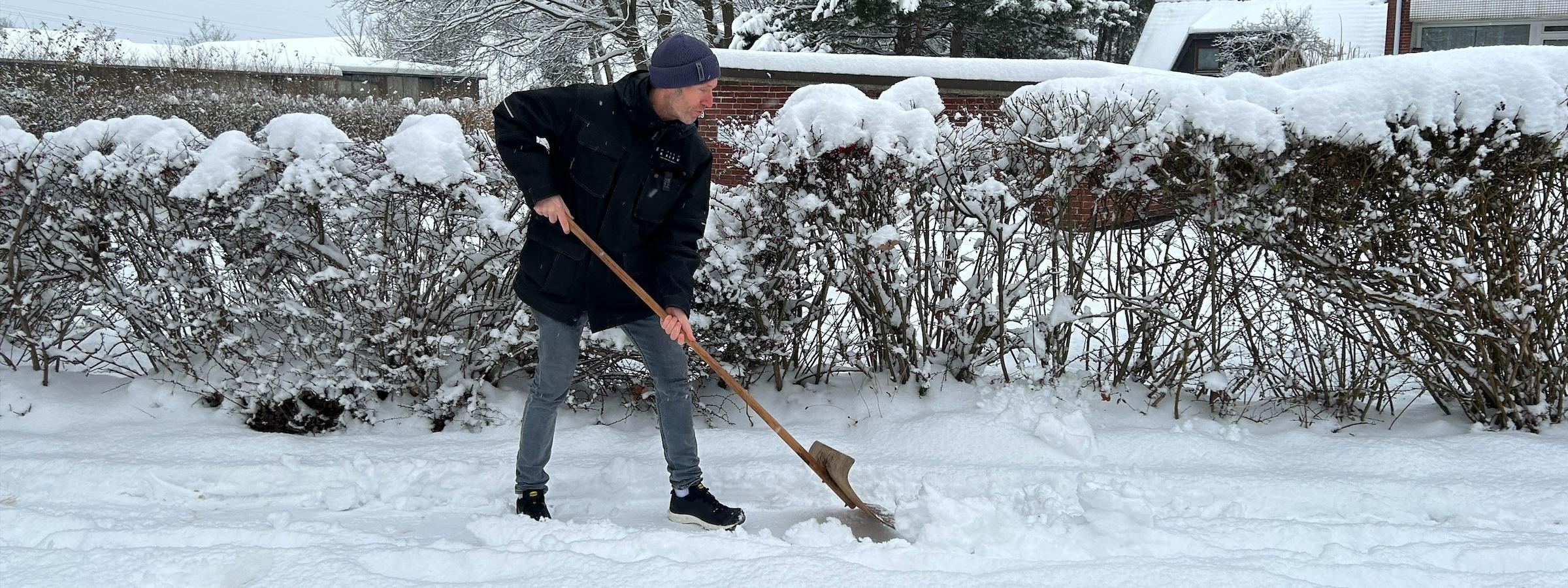 Ein Hausmeister der KAIFU schippt Schnee